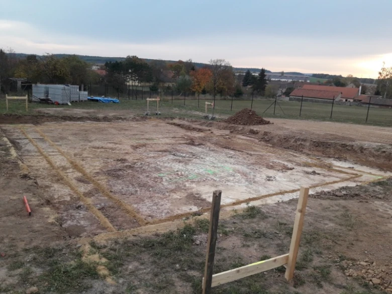 Příprava pozemku pro betonovou základovou desku s vyznačenými liniemi.