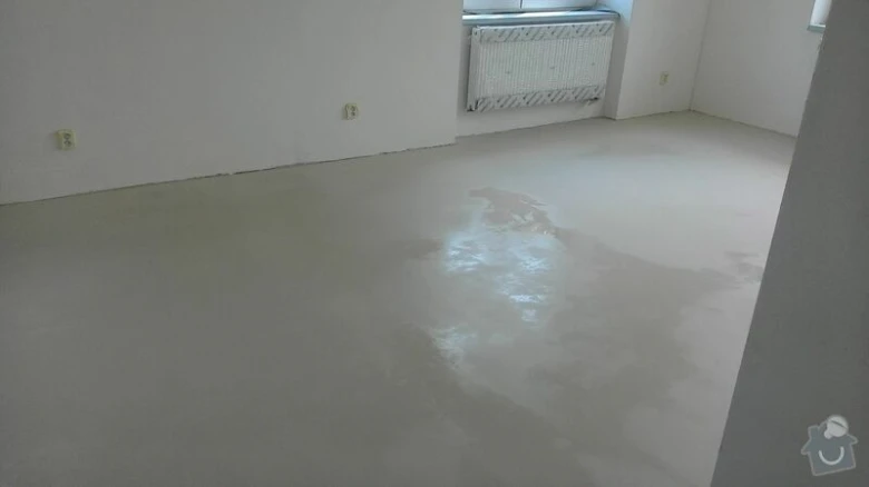 Práce na rekonstrukci bytu: dokončená podlaha v prázdném pokoji.