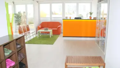 Modern čekárna s oranžovou pohovkou a skříňkami na boty.