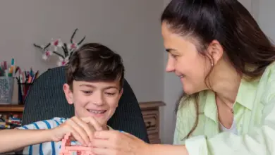 Žena s chlapcem staví geometrické tvary z barevných dílků.