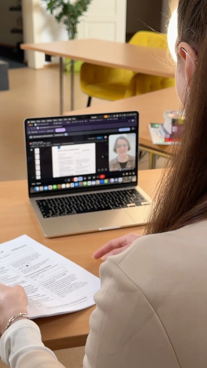 Dívka sedí u stolu s laptopem při domácí výuce.