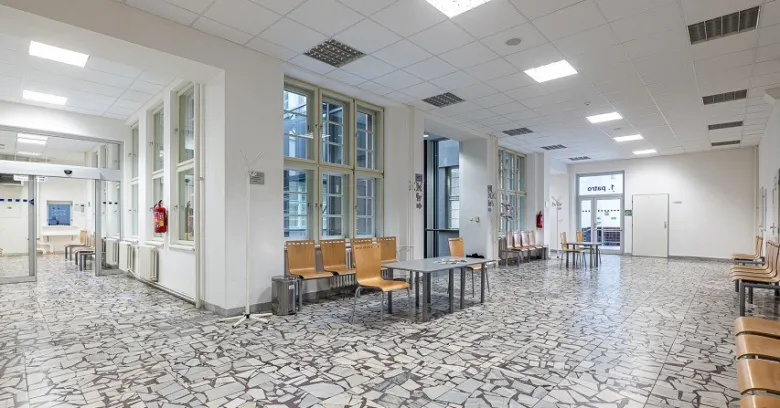 Moderní čekárna v nemocnici s řadami židlí pro pacienty.