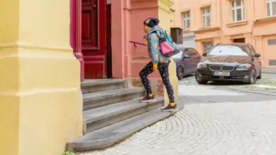 Dítě s batohem vystupuje po schodech venku.