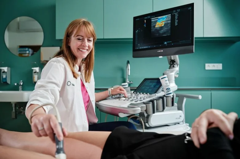 Lékařka provádí ultrazvukové vyšetření pacientovi v ordinaci.
