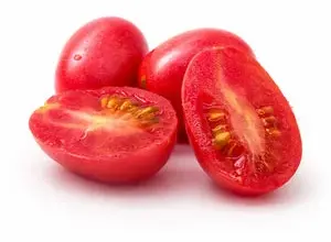 Červená rajčata nakrájená na polovinu s viditelnými semínky.