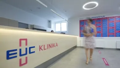 Žena chodí v recepci lékařské kliniky s logem EUC.