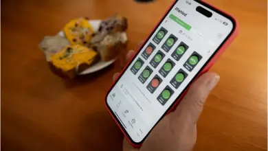 Ruka drží telefon s aplikací na sledování pití alkoholu.