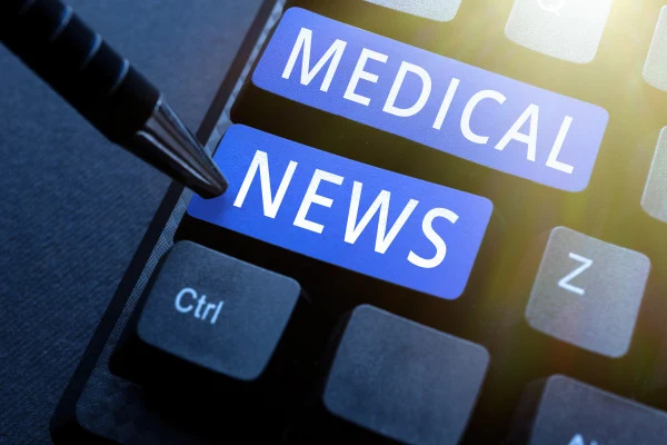 Ruko píšoucí tužka ukazuje na tlačítka s textem Medical News.