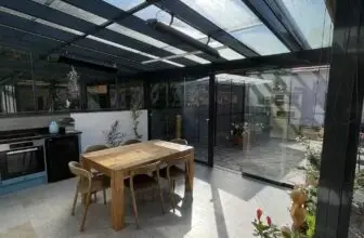 Moderní dřevěná pergola s plexisklovou střechou v zahradním prostoru.
