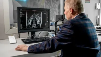 Lékař zkoumá magnetickou rezonanci na počítači pro diagnostiku nádoru.