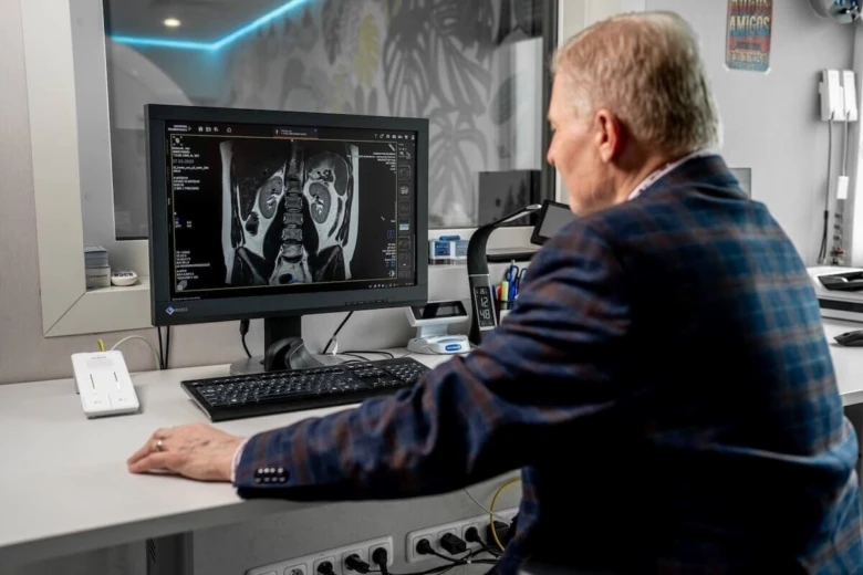 Lékař zkoumá magnetickou rezonanci na počítači pro diagnostiku nádoru.