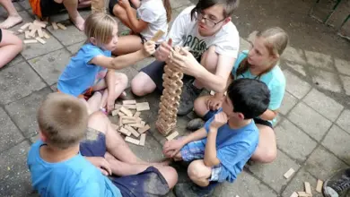 Děti hrají společně s dospelým v místnosti.
