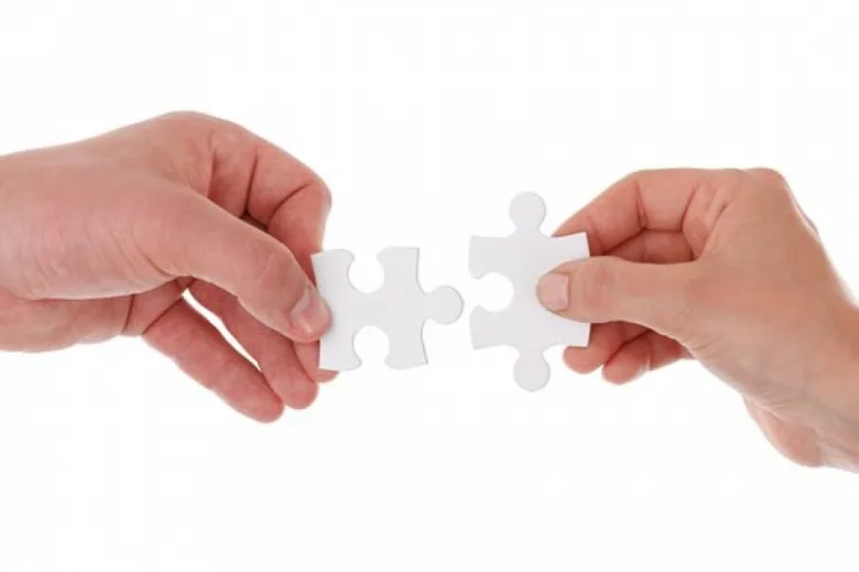 Hands holding puzzle pieces