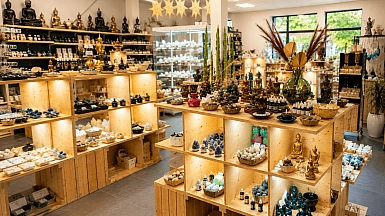 Vnitřek obchodu s buddhistickými soškami a svíčkami pro oslavu.