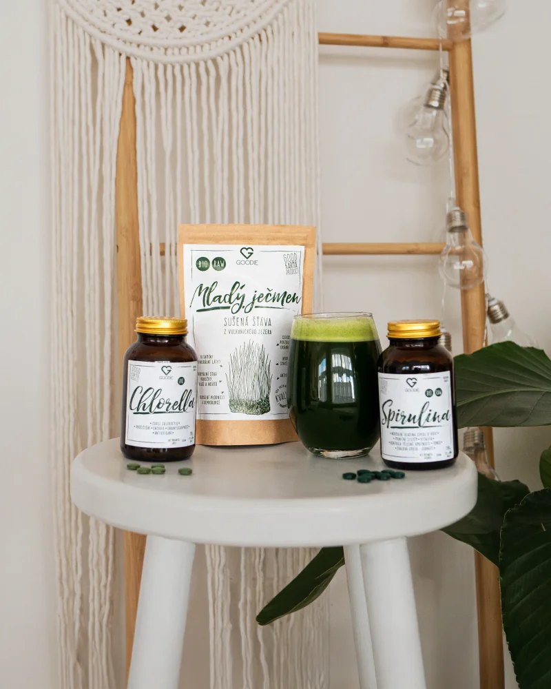 Suplementy jako spirulina a chlorela na bílém stolku.