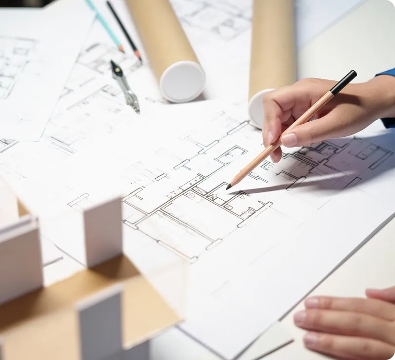 Architektura kreslí plán rekonstrukce panelového bytu s modelkem.