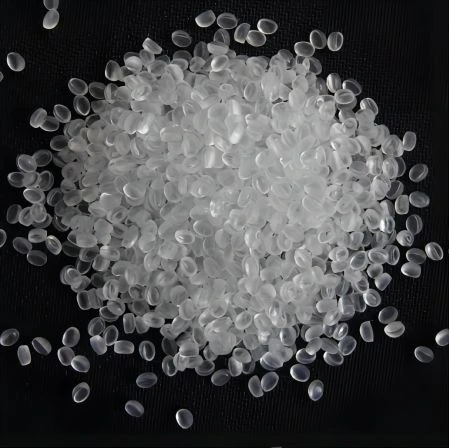 Bílá granulovaná plastová hmota polyethylen tereftalát na černém pozadí.