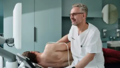 Lékař provádí ultrazvukové vyšetření břicha pacienta ležícího na stole.