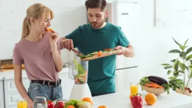 Muž i žena připravují zeleninový smoothie s čerstvými suroviny.
