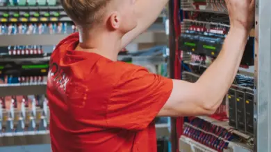 Elektroinženýr pracuje na rozvaděči s kabely a moduly.