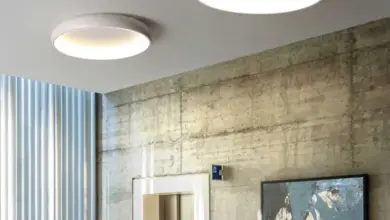Dvě stropní světla v obývacím pokoji s betonovou zdí.