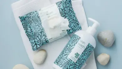 Koupelové produkty s ručníkem na modrém pozadí.