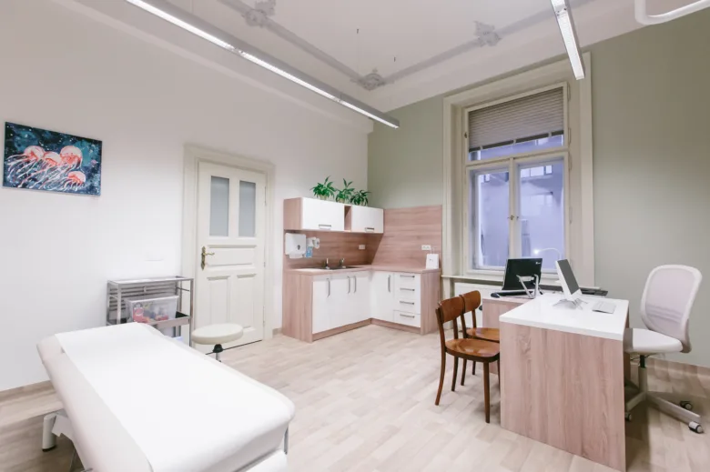 Modern lékařská ordinace s vyšetřovacím stolem pro pacienty.