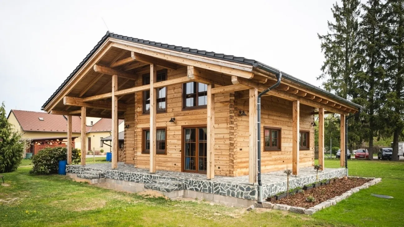 Moderní dřevěný dům s okrasnou zahradou před ním.