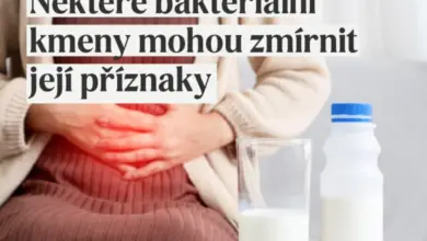 Žena drží břicho vedle mléka při trávicích potížích.