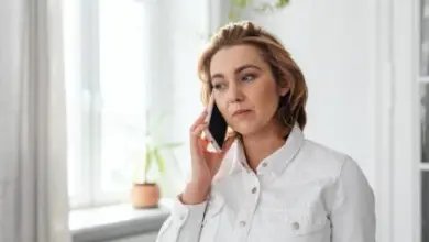 Dívka mluví na mobilu u okna, příznaky první menstruace.