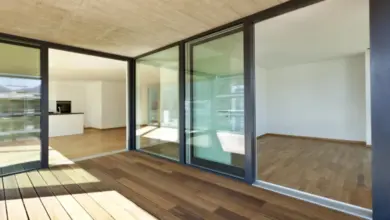 Moderní lodžie s dřevěnou podlahou a skleněnými stěnami v bytě.