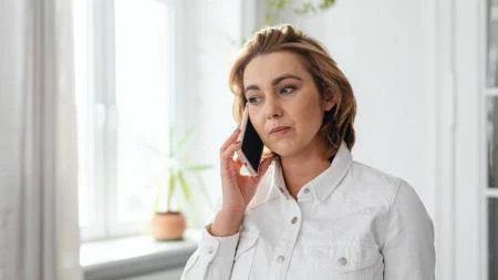 Žena mluví na telefonu, přírodní léčba bolesti ucha.