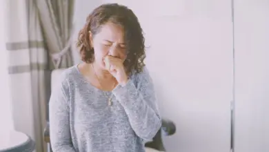 Woman coughing indoors